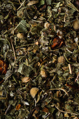 Therapeutic natural tea with berries, a pile of welding on a studio table, macro shot