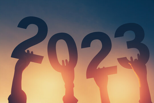 Happy new year 2023 background new year holidays card with bright sunlight, with arms raised new year 2023.