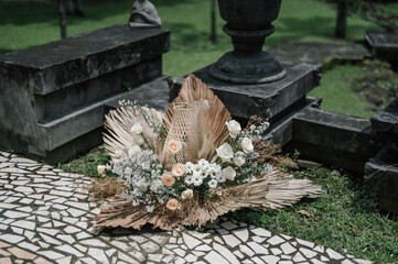 Ornamental wedding decoration with dried leaf, rattan root and fresh flowers on sunny afternoon daylight for wedding ceremony or holy matrimony outdoors