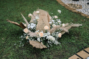 Ornamental wedding decoration with dried leaf, rattan root and fresh flowers on sunny afternoon daylight for wedding ceremony or holy matrimony outdoors