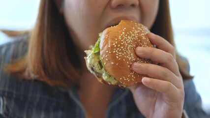 Woman enjoy eating a hamburger 