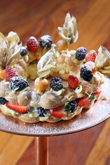 Fruit pie being sprinkled with icing sugar