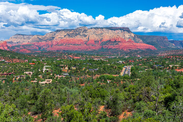 Fototapeta na wymiar Elevated scenic view of an upscale residential neighborhood in Sedona surrounded by stunning mountains and red hills