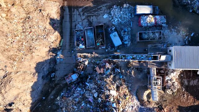 Landfill with Construction waste (CDW). Trash disposal for recycling and re-use. Excavator log grab crane on landfill. Recycling of Construction waste or debris. Secondary raw. Wood Waste Recycling.
