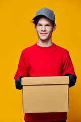 a courier in a cap and a red T-shirt brought a cardboard box