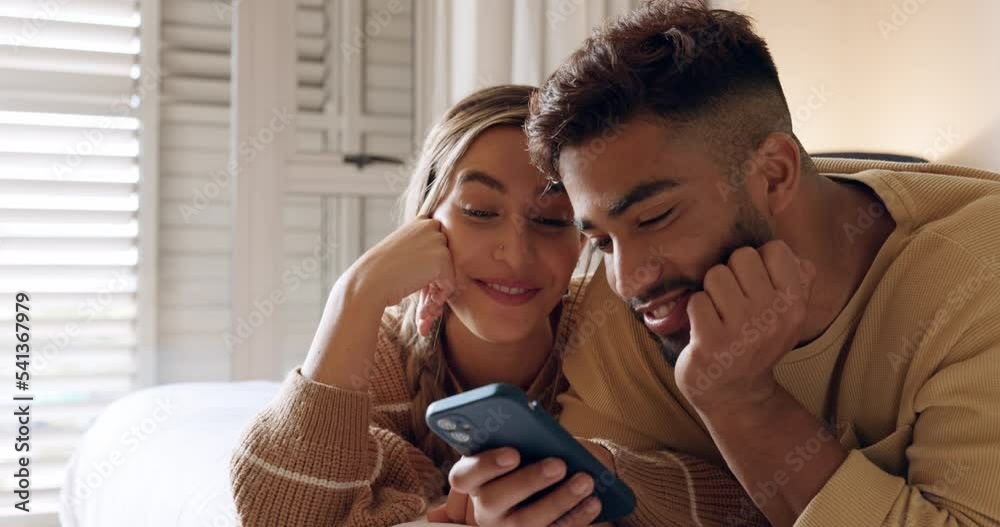 Sticker Relax, phone and couple in bed for social media, web and browsing in their home together, happy and smile. Love, planning and internet booking with interracial man and woman discuss plans in bedroom