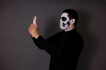 hombre maquillado de catrin o calavera para el dia de muertos como tradición mexicana con cara...
