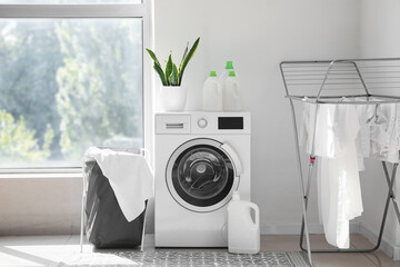 Interior of light laundry room with washing machine, basket and dryer - obrazy, fototapety, plakaty
