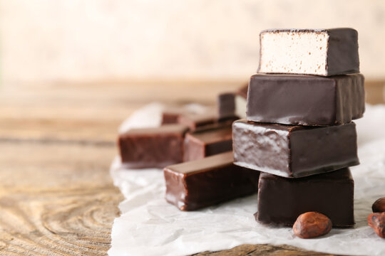 Stack of tasty bird's milk candies on wooden table