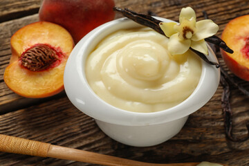 Bowl of delicious vanilla pudding on wooden table, closeup