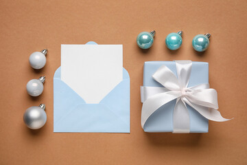 Composition with blank card, Christmas gift and balls on color background