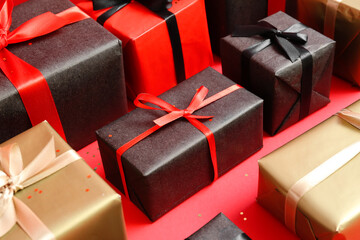 Gift boxes on red background, closeup. Black Friday sale