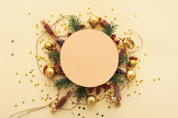 Blank card with Christmas decor, fir branches and candies on beige background
