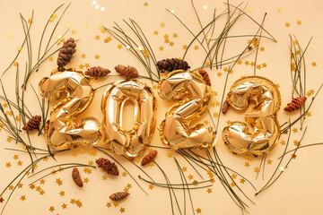 Figure 2023 made of balloons with confetti, fir branches and pine cones on beige background