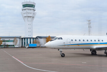Airport controller tower and aircraft on the airfield runway, outdoors
