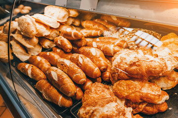 bakery products, delicious and fresh wheat bread and sweet rolls and buns on the shop window