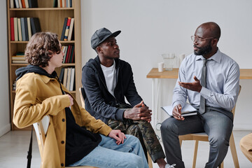 African coach talking to students and explaining them material at class