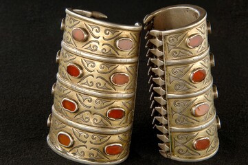 Antique bracelets with engraving and precious stones isolated on a black background