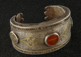 Antique bracelet with engraving and precious stones isolated on a black background