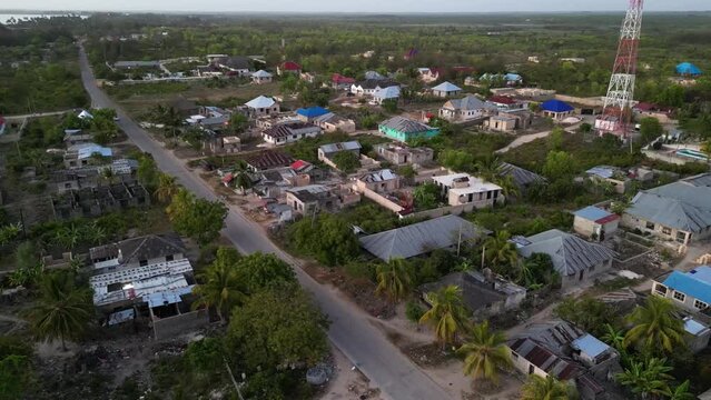Radio tower and some homes under construction in Uroa Beach Zanzibar Tanzania Africa, Aerial orbit around shot