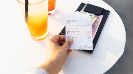 Woman hand with bill holder in a restaurant of soft drink for check and cash money