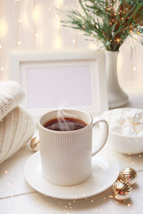 Obraz na płótnie Canvas Winter, Christmas, New Year decorations composition, concept, background. White Mug, cup of tea, coffee, steam, meringue, knitted plaid. Christmas lights. Christmas mood morning. Christmas card