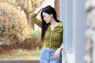 Candid lifestyle Portrait of happy young beautiful asian sexy woman enjoying life outdoor at spring. Smiling millennial girl with perfect clear glow skin and long brunette hair