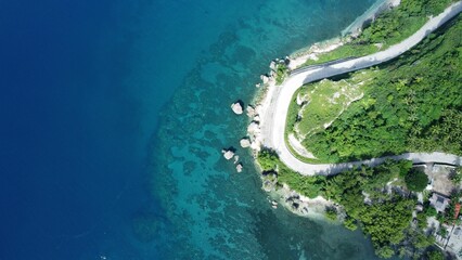 Obraz premium Aerial shot of the shore in Negros Oriental, Philippines, with the daylight reflection in the water