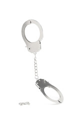 Close-up shot of metal handcuffs with an adjoining chain and metal unlocking keys. The metal...