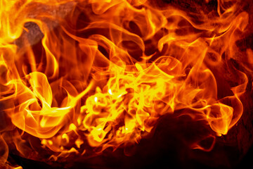 Burning fire close up. Bright orange and red flames on a dark background. Open flame heating. Problems with heating and gas.