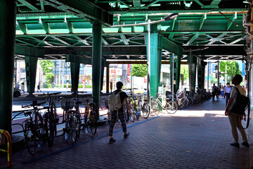 新橋駅ガード下の駐輪場と歩行者シルエット
