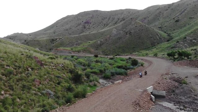 Aerial shot of bike riders riding on a rough road near Khuzdar in Balochistan, Pakistan. 
