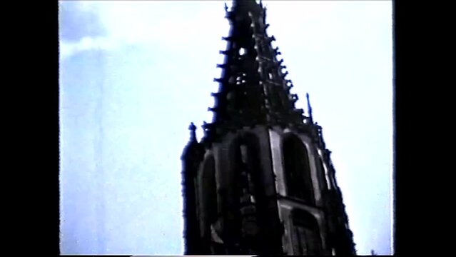 Bern, Switzerland 1960s: Facade and Portal of Cathedral and The Mosesbrunnen (Moses Fountain), the statue represents Moses bringing the Ten Commandments - 1960s vintage video 8mm