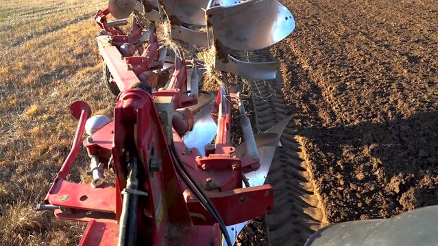 Farmer lowers the plough to straighten the plowed field