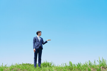外で手のひらで右を指すビジネスマン