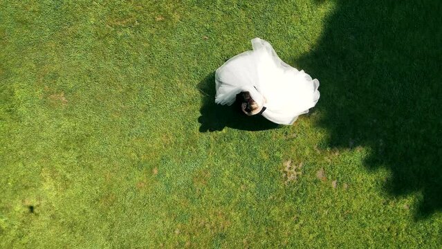 Aerial Top view of the wedding dance of the newlyweds. The groom spins the bride while holding him in his arms.