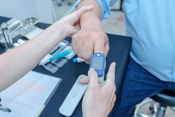  Doctor checking oxygenation with fingertip pulse oximeter. Saturation blood of oxygen. Measuring the patient's blood saturation with an oximeter