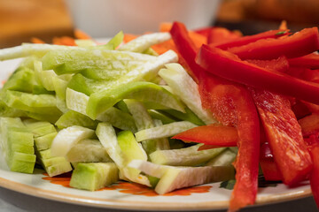 Zucchini, red bell peppers and carrots, sliced straw, lie on a plate. Close-up. Dietary, healthy food. Vegetarian food.