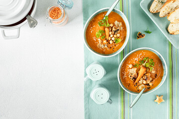 Vegetarian autumn pumpkin and carrot soup with chickpeas and quinoa. Comfort food, autumn-winter concept of healthy food.