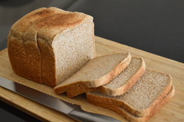 Wholemeal sliced bread on a bamboo chopping board. 