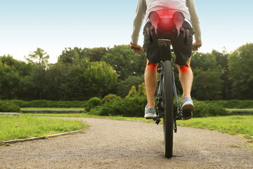 Problem of injured coccyx. Man riding bicycle on road