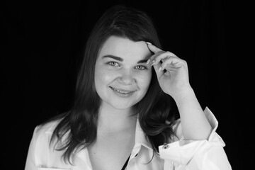 Portrait of a Beautiful girl in a white shirt in the dark, black and white photo