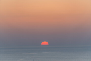 Orange sun setting on the Aegean Sea in Greece