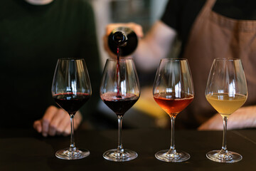 sommelier pouring wine into wine glasses for wine tasting