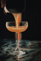 Pouring a glass of cocktail on a marble table