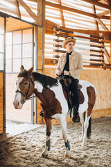 Handsome cowboy man riding a horse on a ranch.