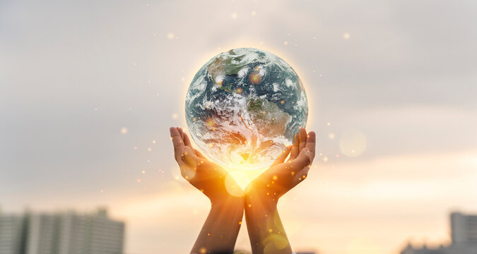 World environment day concept. Human hands holding earth global over blurred city background.