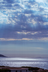 Amazing sky before the rain over sea. Ray of sunlight through dark clouds. Bright glare on the sea before the storm.