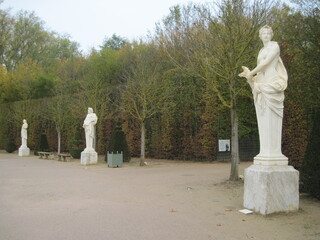 Statue in the park. Walking in the park. Tall trees in the fall. Scenic pathway in the garden