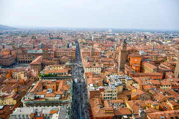 Obraz premium Aerial Cityscape view from the tower Asinelli on Bologna old town center with Maggiore square in Italy.Colorful sky over the historical city center with car traffic and old buildings